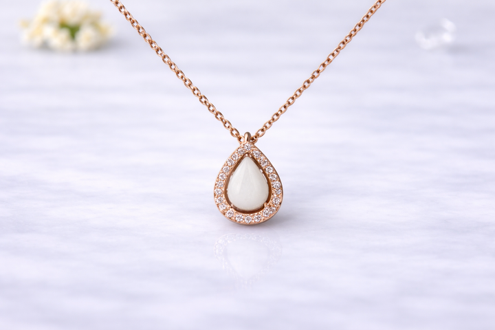 Teardrop-shaped necklace with a white stone on a light background